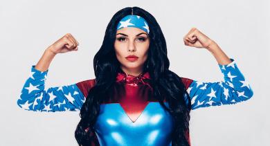 
		a woman in a superwoman costume and power pose
	